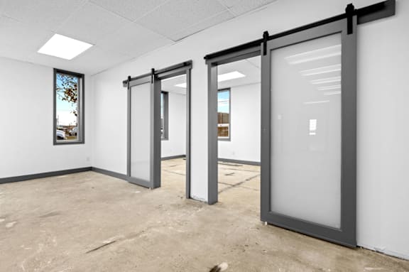 Three glass doors in a white room.