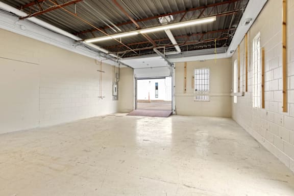 Empty industrial space with white walls and a concrete floor.