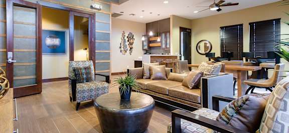 a Clubhouse lobby with a fireplace and a table with chairs with a stone kitchen island