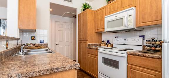 a Clubhouse lobby with a fireplace and a table with chairs with a stone kitchen island