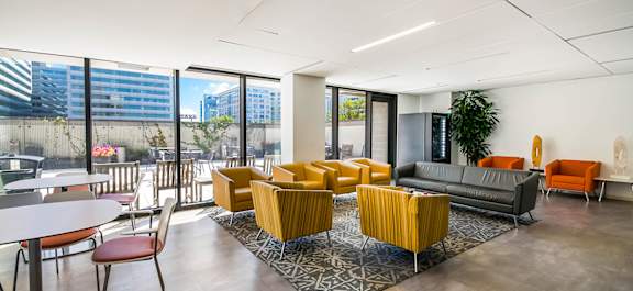 a Clubhouse lobby with a fireplace and a table with chairs with a stone kitchen island