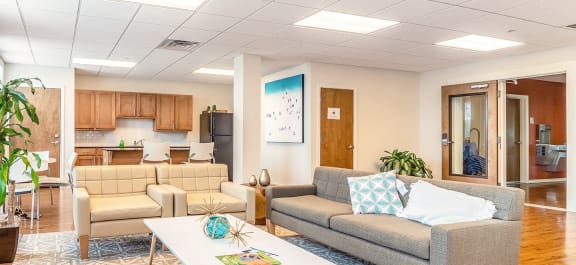 a Clubhouse lobby with a fireplace and a table with chairs with a stone kitchen island