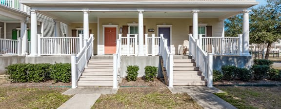 a white house with a porch and stairs