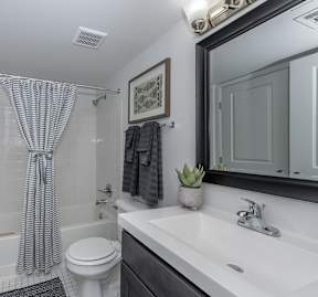 A bathroom with a white toilet, a white sink, and a shower curtain.