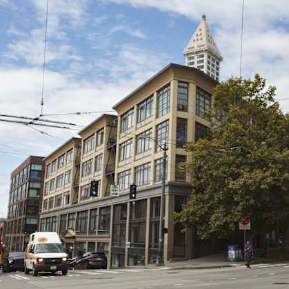 A street view of a city with a building in the foreground and a bus in the background.