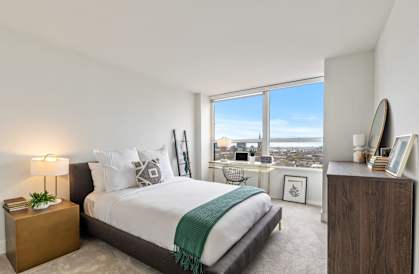 a bedroom with a bed and a large window