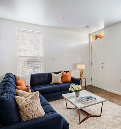 A living room with a blue sofa, a chair, and a coffee table.