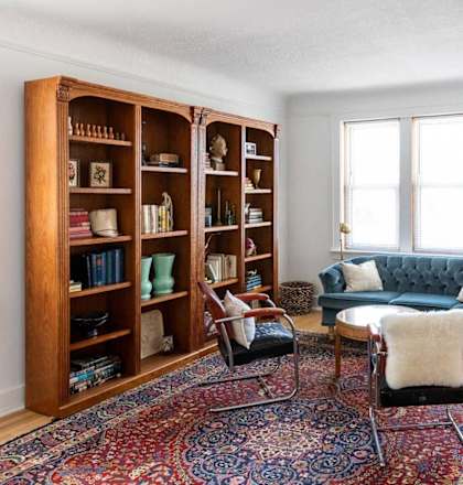 a living room with a blue couch and a bookshelf
