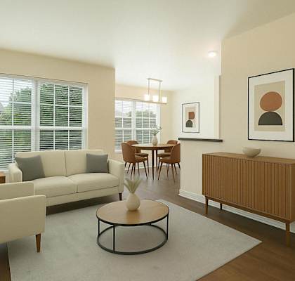 A living room with a white sofa, a wooden side table, and a coffee table.