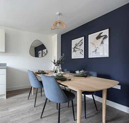 A modern kitchen with a dining table set for two.