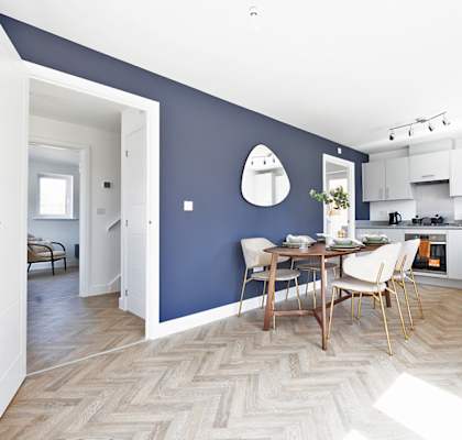 A kitchen with a dining table and chairs in the middle of the room.