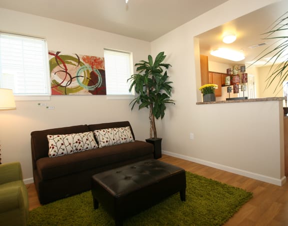 a living room with a couch and a dining table and a refrigerator surrounded by cabinets