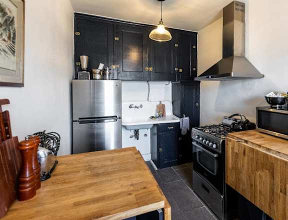 a kitchen with a wooden table and a stove and refrigerator