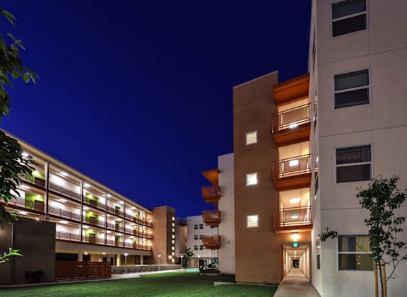 A modern building with a well-lit entrance and balconies.