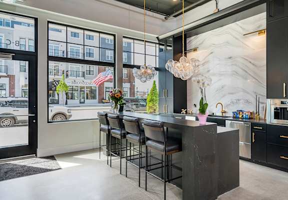 A kitchen with a marble backsplash and a bar area.