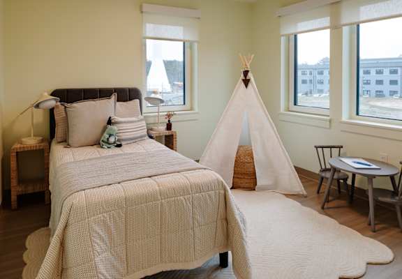 A bedroom with a teepee and a bed.
