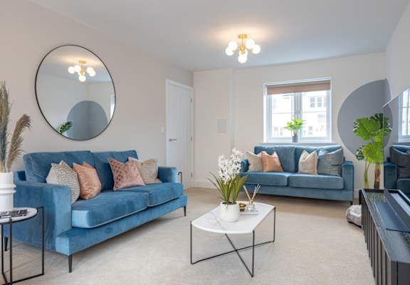 A living room with a blue couch and a white coffee table.