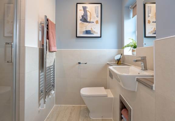 A bathroom with a toilet, sink, and shower.