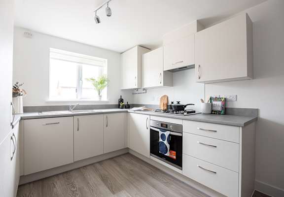 A kitchen with a white oven and cabinets.