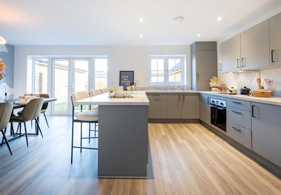A modern kitchen with a dining table and chairs.