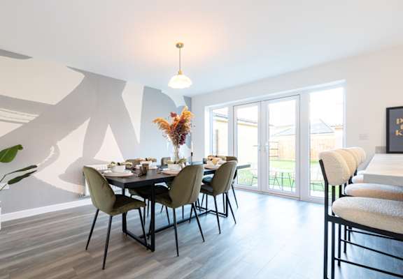 A dining room with a table set for six people.