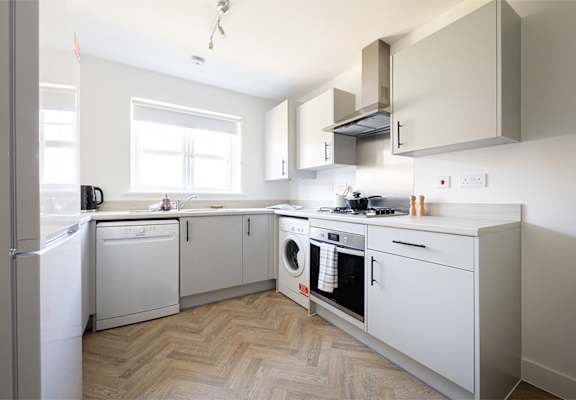 a small kitchen with white appliances and a window