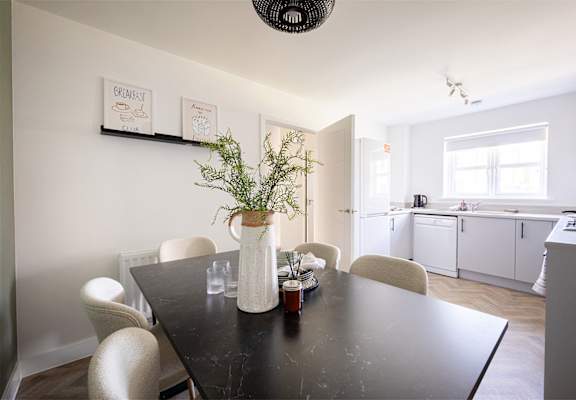 a dining room with a table and chairs and a kitchen