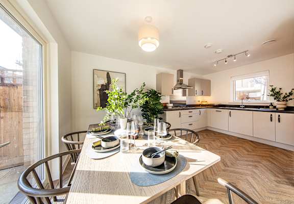 A modern kitchen with a dining table set for four.