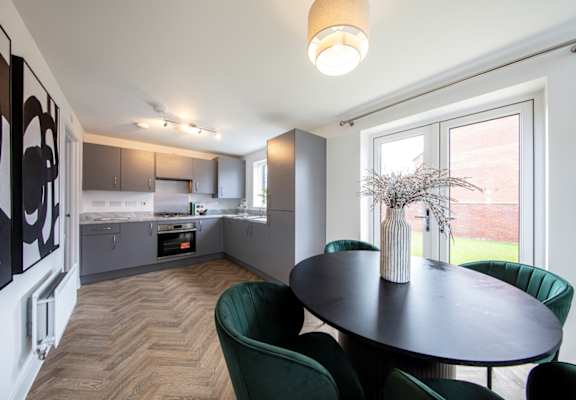A modern kitchen with a dining table and chairs.