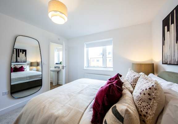 A bedroom with a large bed and a mirror on the wall.