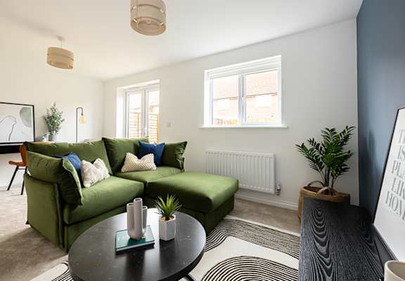 A living room with a green couch and a coffee table.