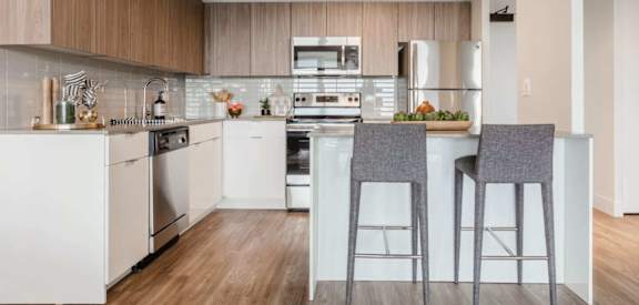 a kitchen with a bar and stools in front of a counter top