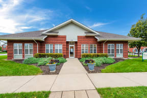 a red brick leasing office with a sidewalk in front of it at Horace Mann apartments and townhomes in Gary, IN