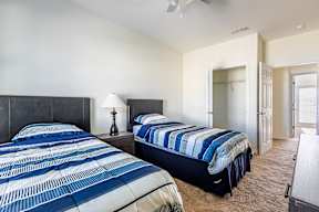 A bedroom with two beds and a ceiling fan.