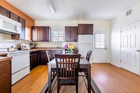 A kitchen with a table and chairs in the middle.