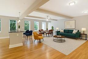 A living room with a green couch and wooden floors.