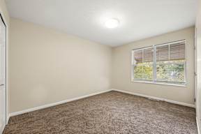 A room with a window and carpeted floor.