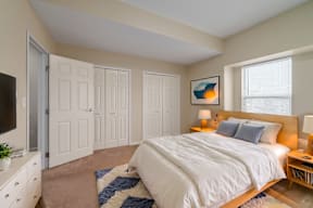 A bedroom with a large bed and a painting on the wall.