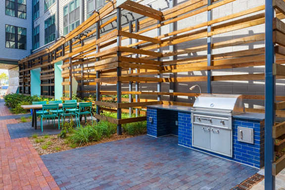 A patio with a grill and chairs. at Coda at Bryant Street, Washington, DC 20002