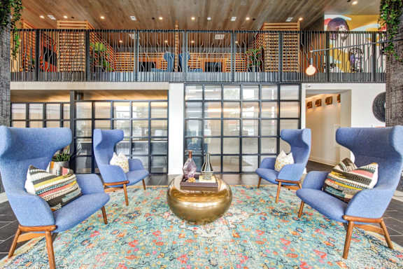 A room with blue chairs and a gold table. at Coda at Bryant Street, Washington, DC 20002