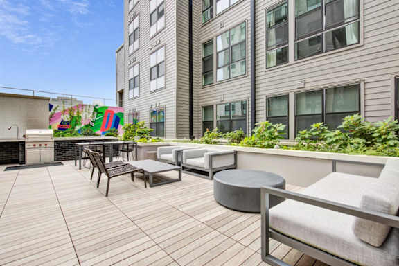 A patio with a table and chairs is surrounded by a building. at Coda at Bryant Street, Washington, DC 20002
