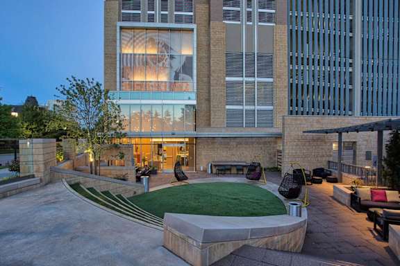 A modern house with a glass window and a green lawn in front. at Uptown by Onni Apartments, Apartments, Dallas, TX