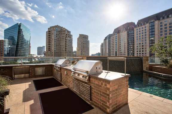 A sunny day in a city with a pool and a building with a white roof.