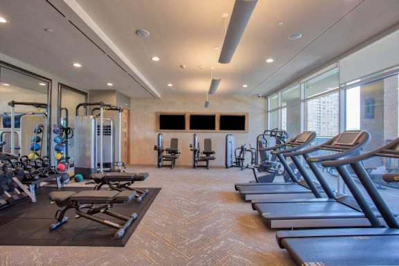 A gym with treadmills, weights, and exercise equipment. at Uptown by Onni Apartments, Apartments, Dallas, TX