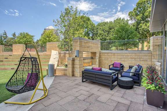 A backyard with a swing chair, a couch, and a table. at Uptown by Onni Apartments, Apartments, Dallas, TX