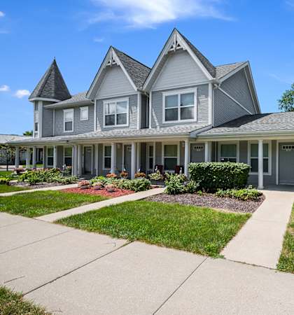a gray house with a sidewalk in front of it