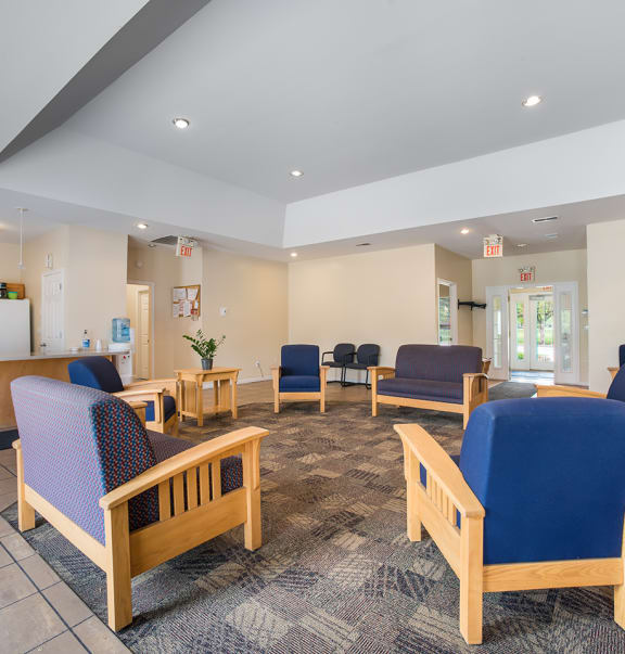 a lobby with chairs and a table and a fireplace