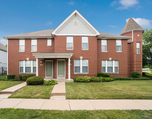 a brick house with a sidewalk in front of it