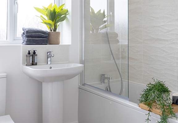 A white bathroom with a sink, toilet, and bathtub.