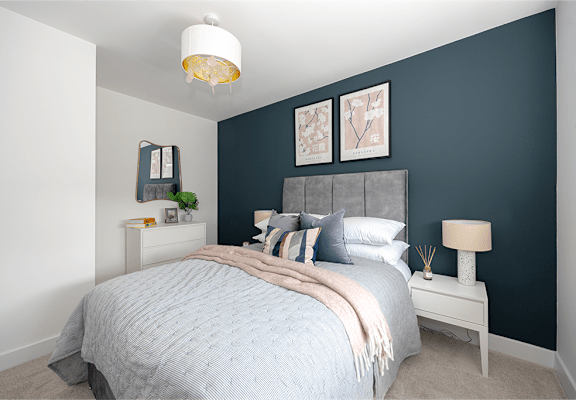 a bedroom with a blue wall and a bed with a grey headboard
